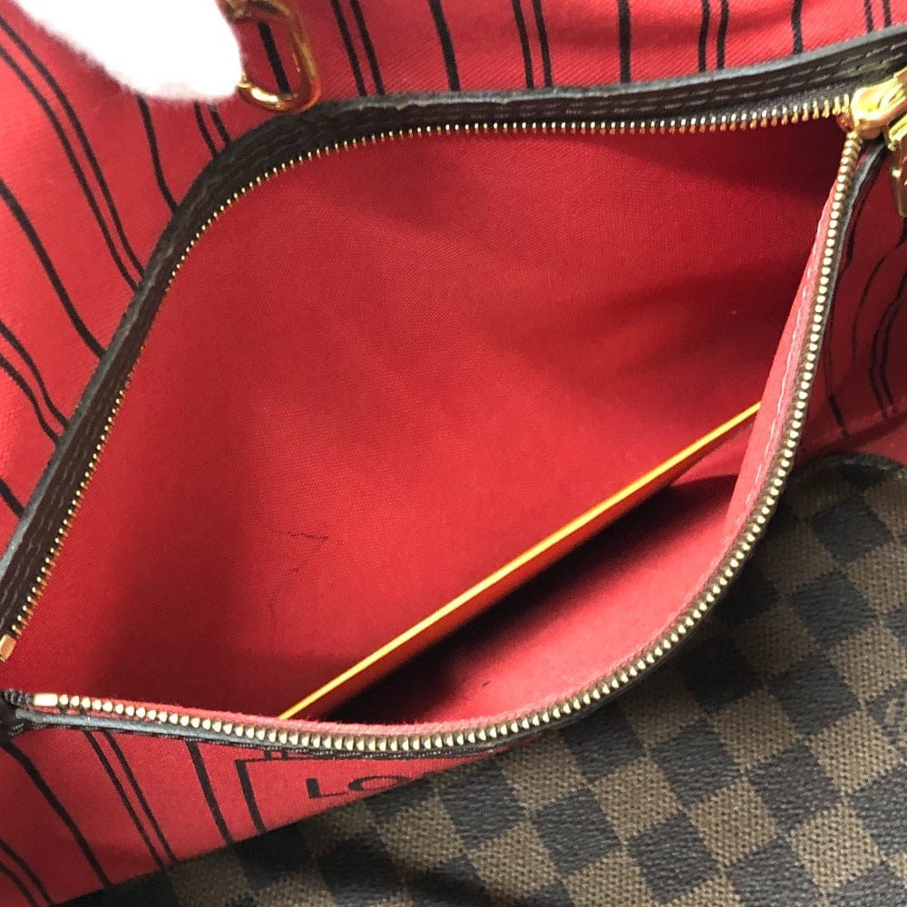 Red handbag with gold zipper on a checkered surface