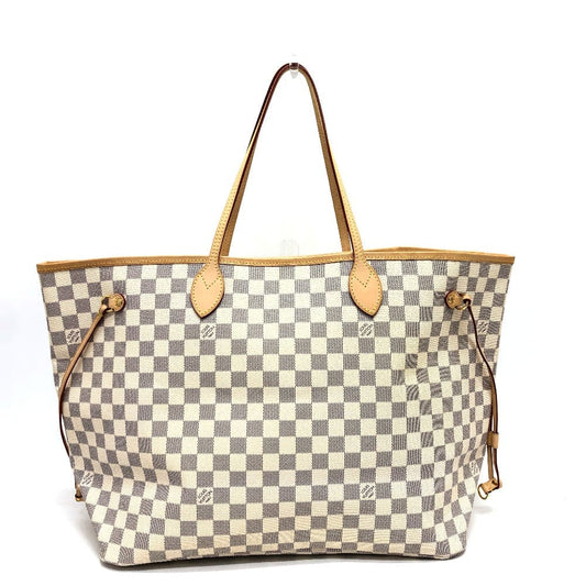 Designer handbag with checkered pattern and brown handles on a white background