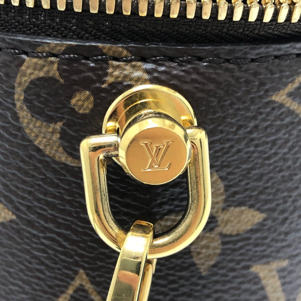 Close-up of a gold zipper pull on a Louis Vuitton bag with monogram pattern.