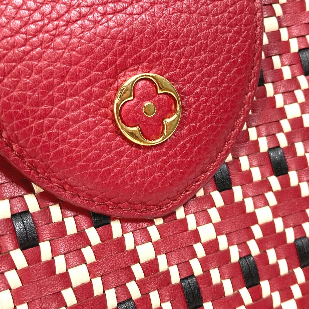 Red leather pouch with a gold emblem on a red woven background