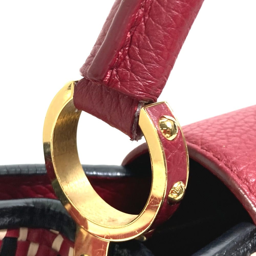 Close-up of a gold ring on a red leather strap with a blurred background