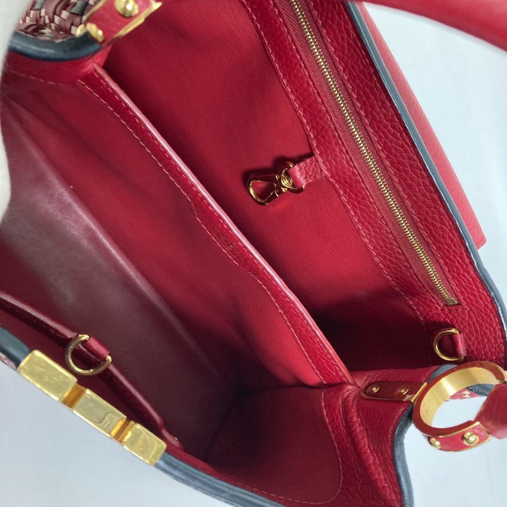 Close-up of a red handbag with gold accents on a white background