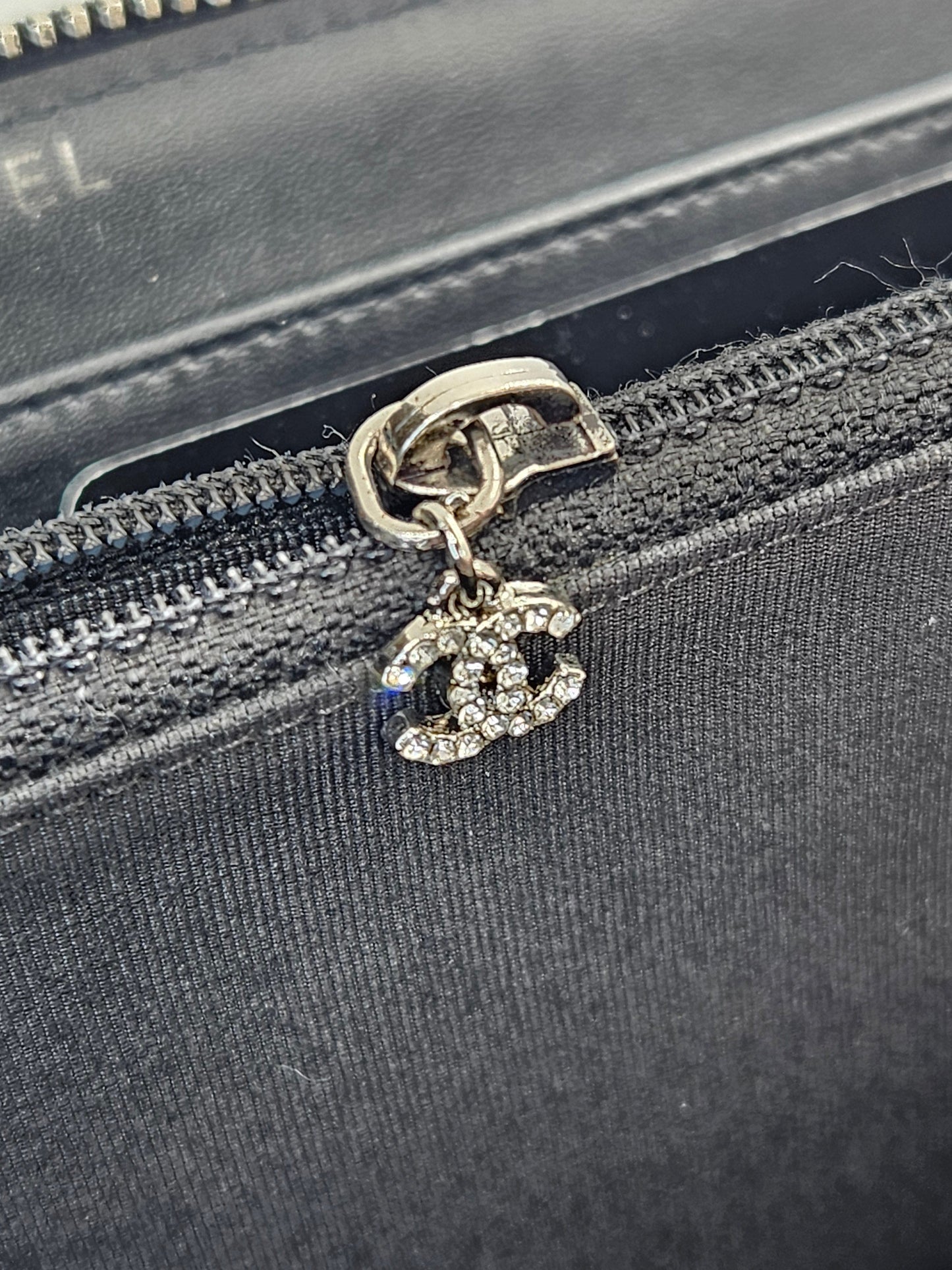 Chanel logo charm on a black zipper