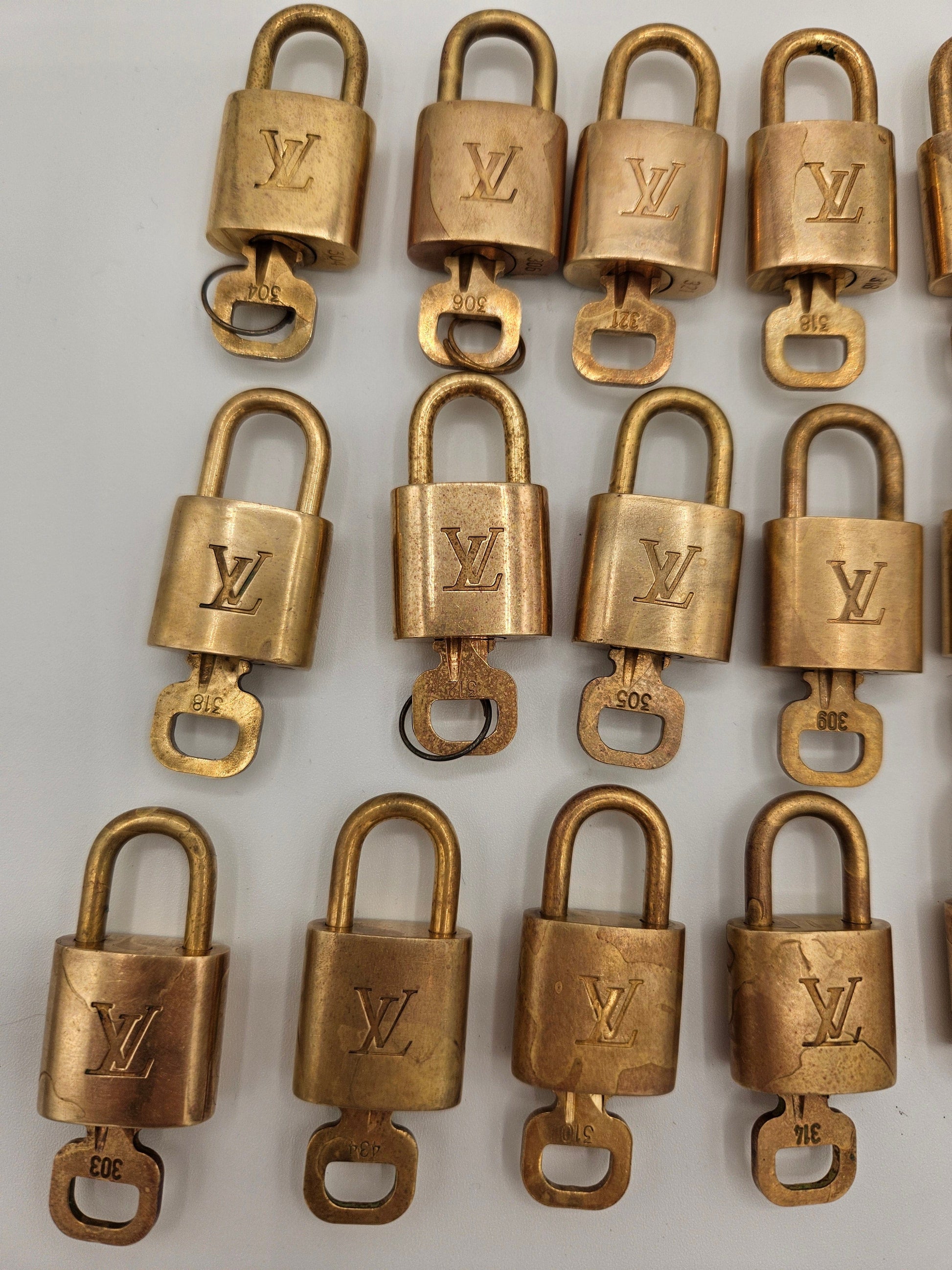 Multiple gold padlocks with a visible brand logo on a white background