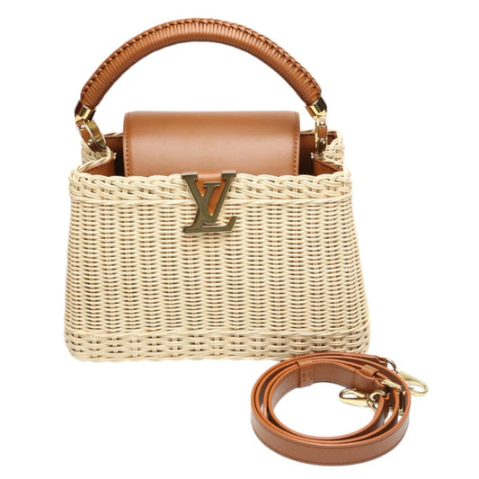 Woven handbag with brown handle and strap on a white background