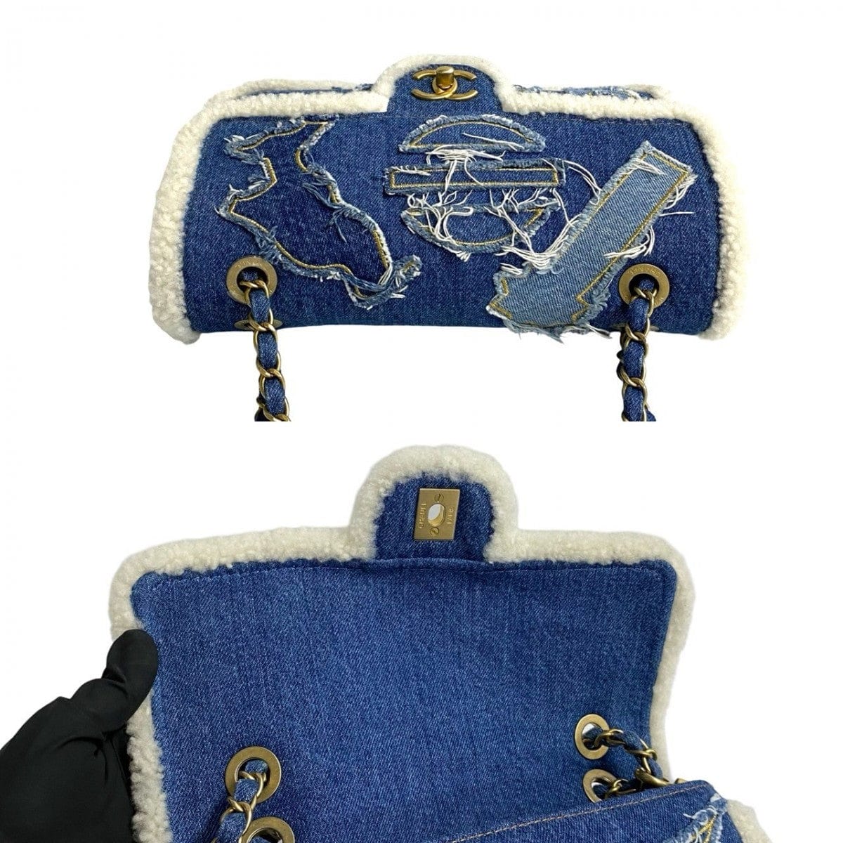 Blue denim bag with white embroidery and gold accents on a white background