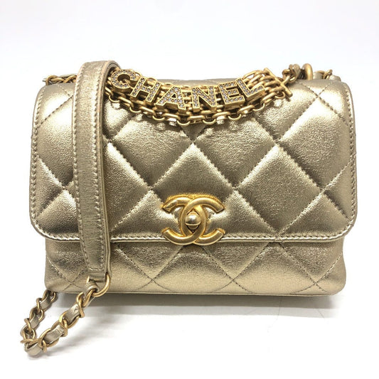 Gold quilted Chanel handbag with chain strap on a white background