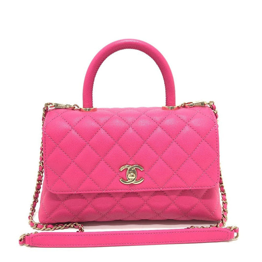 Pink quilted handbag with gold chain and clasp on a white background