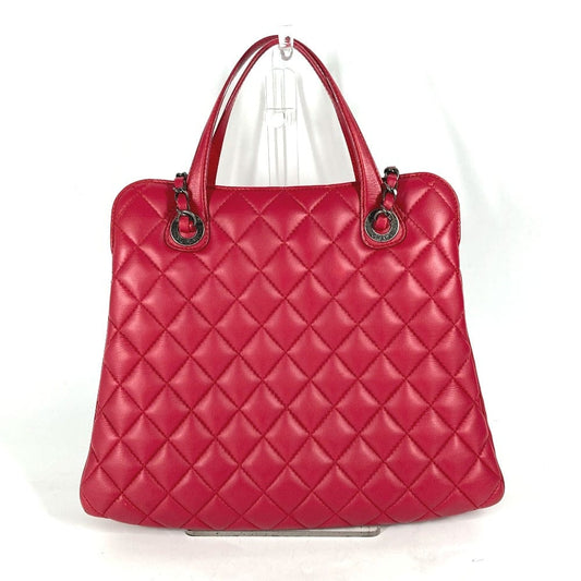 Red quilted handbag on a white background
