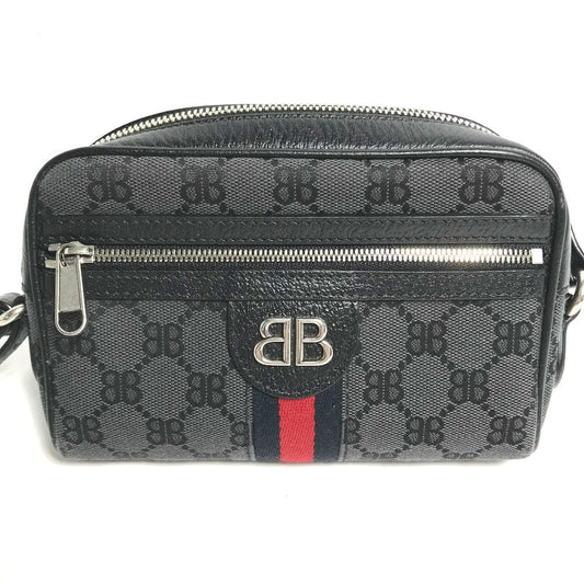 Black handbag with a red stripe and silver logo on a white background