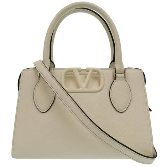 Beige handbag with a shoulder strap on a white background