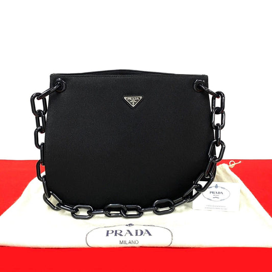 Black Prada handbag with chain detail on a white background