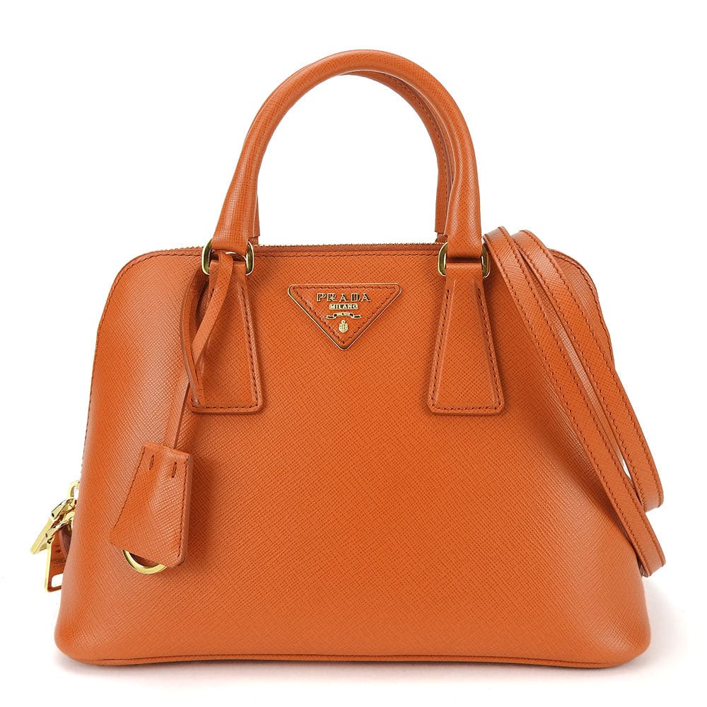 Orange handbag with gold accents on a white background