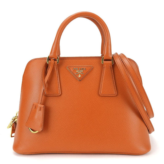 Orange handbag with gold accents on a white background
