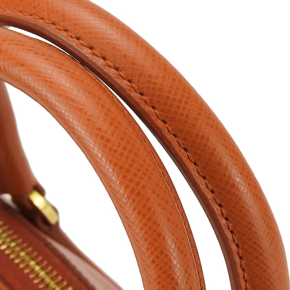 Close-up of a brown leather handbag handle on a white background