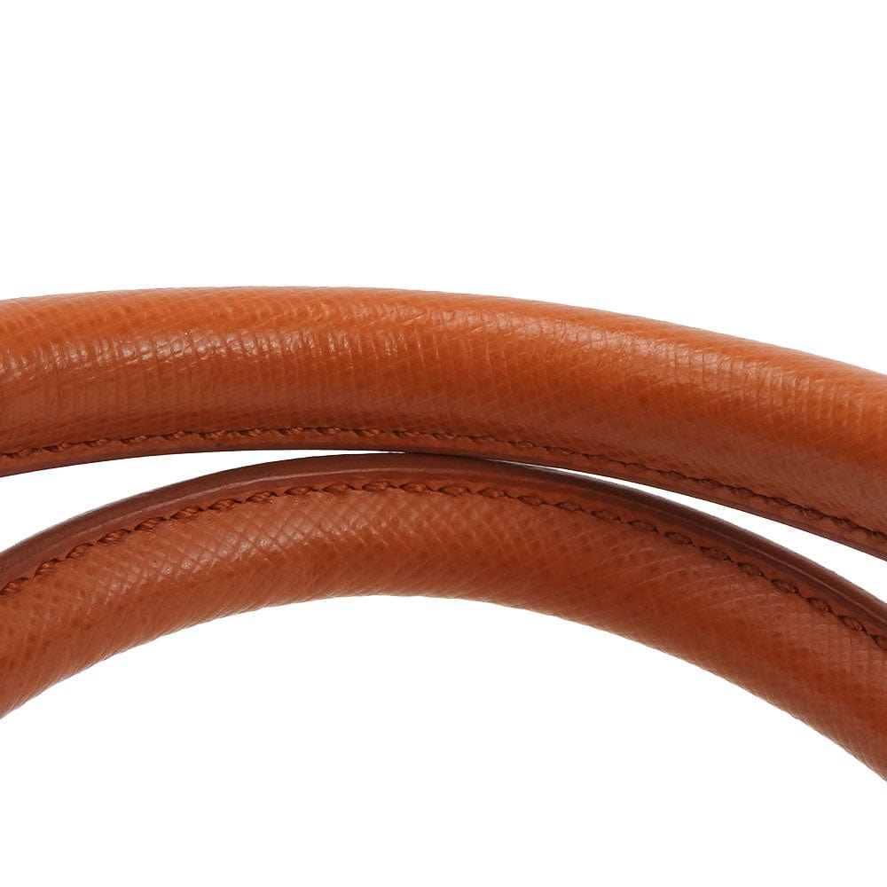 Close-up of a brown leather belt on a white background