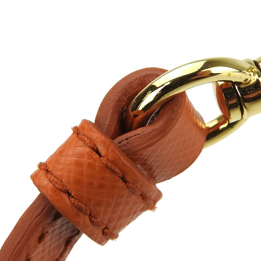 Brown leather strap with a gold metal clip on a white background