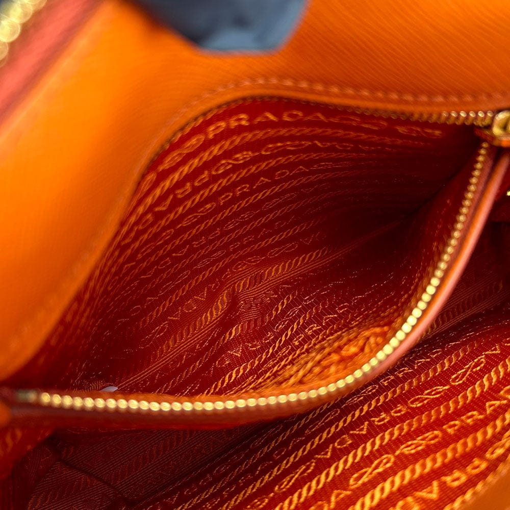 Close-up of a Prada handbag with visible branding and texture.