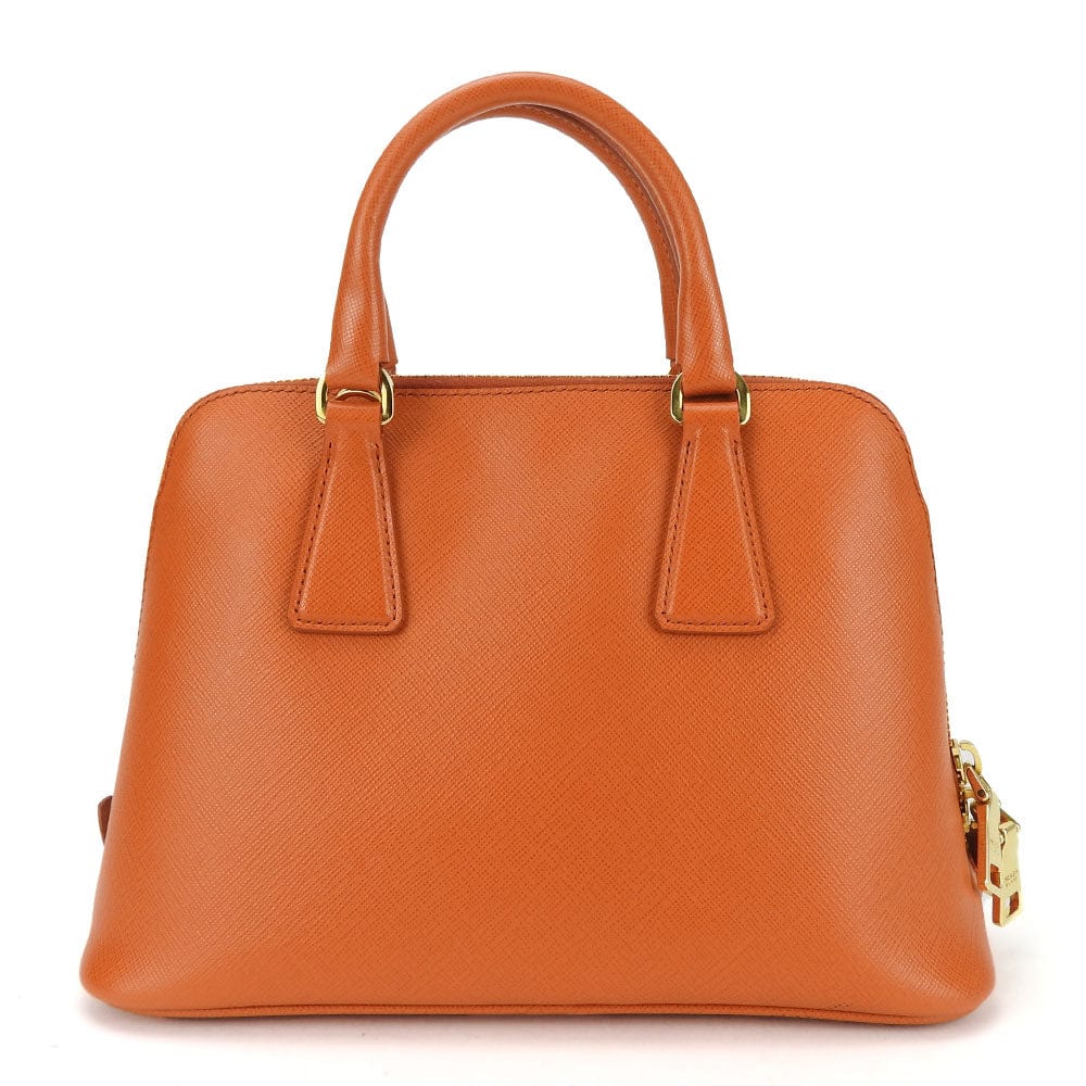 Brown handbag with gold accents on a white background