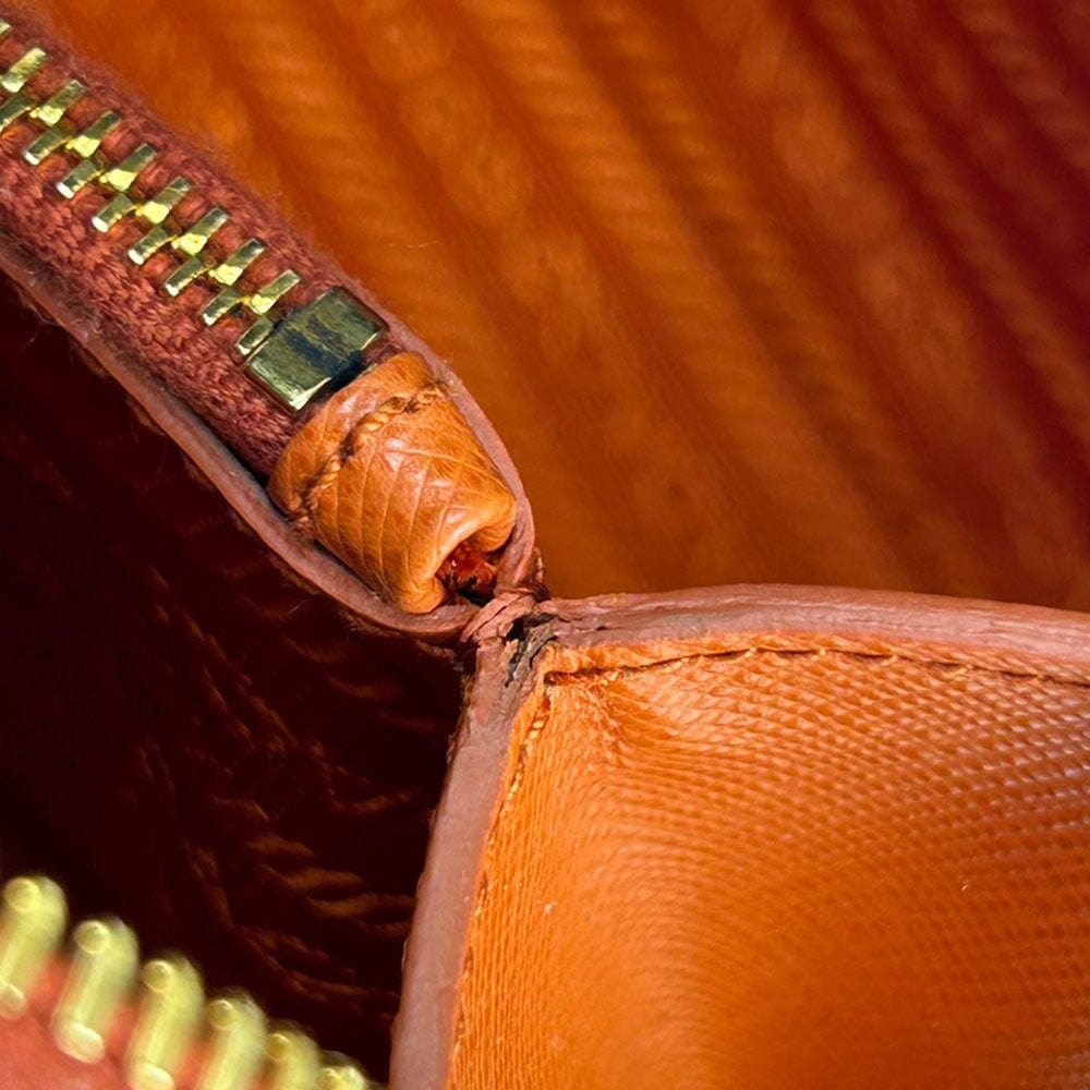 Close-up of a brown leather bag with gold zipper details