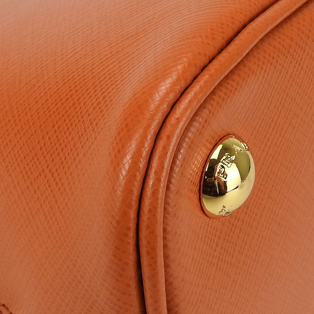 Close-up of a brown leather handbag with a gold clasp