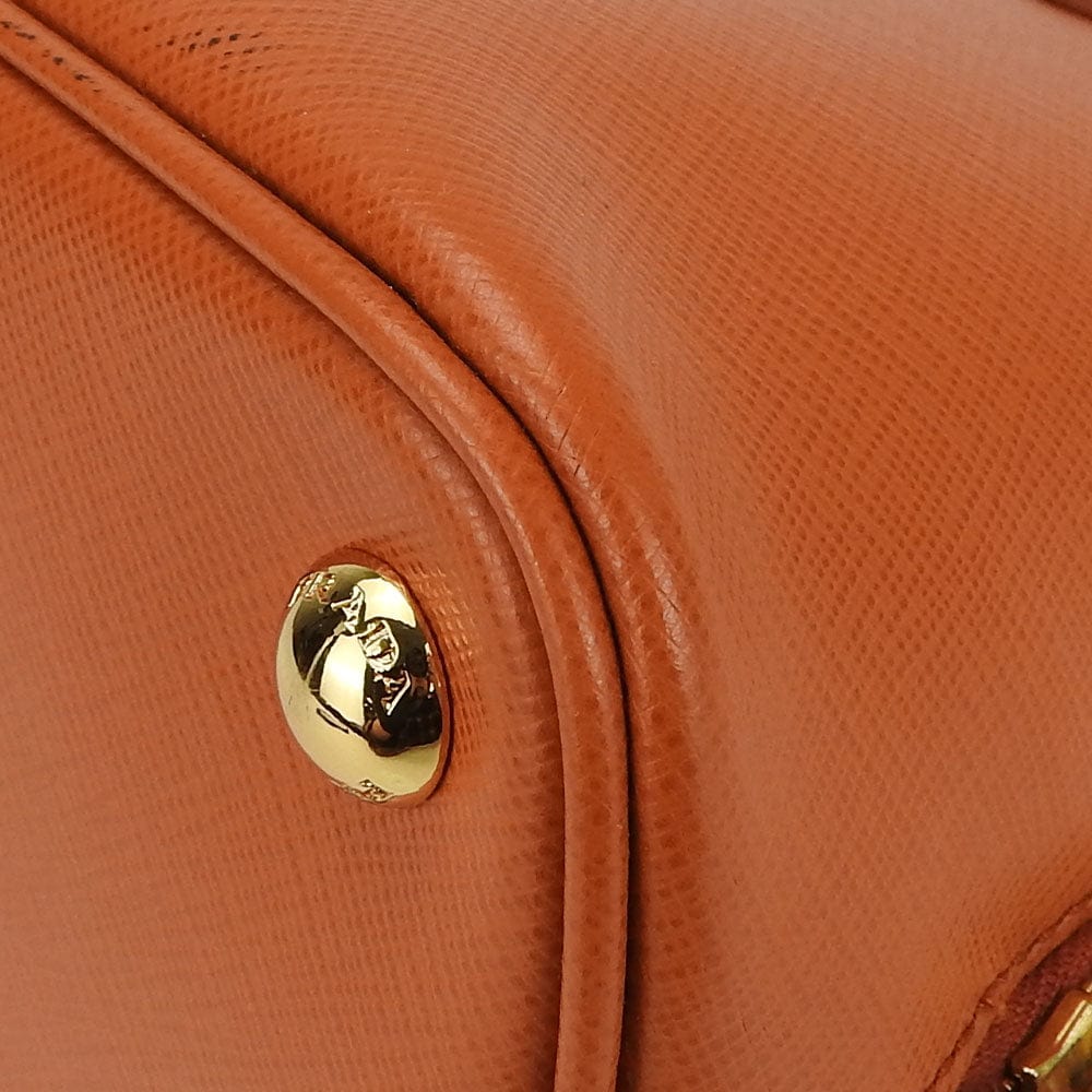 Close-up of a brown leather handbag with a gold clasp.