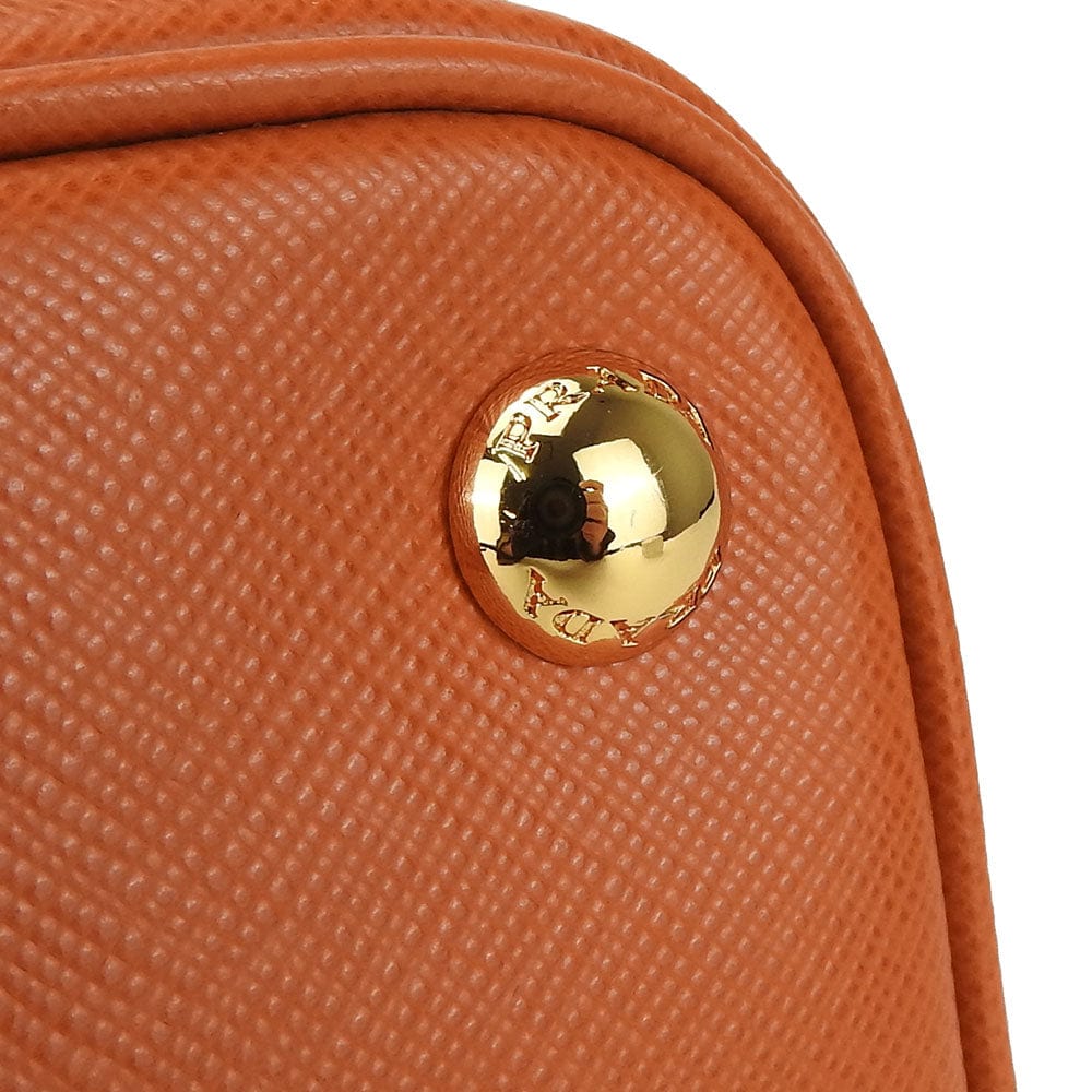 Close-up of a brown textured handbag with a gold clasp on a white background