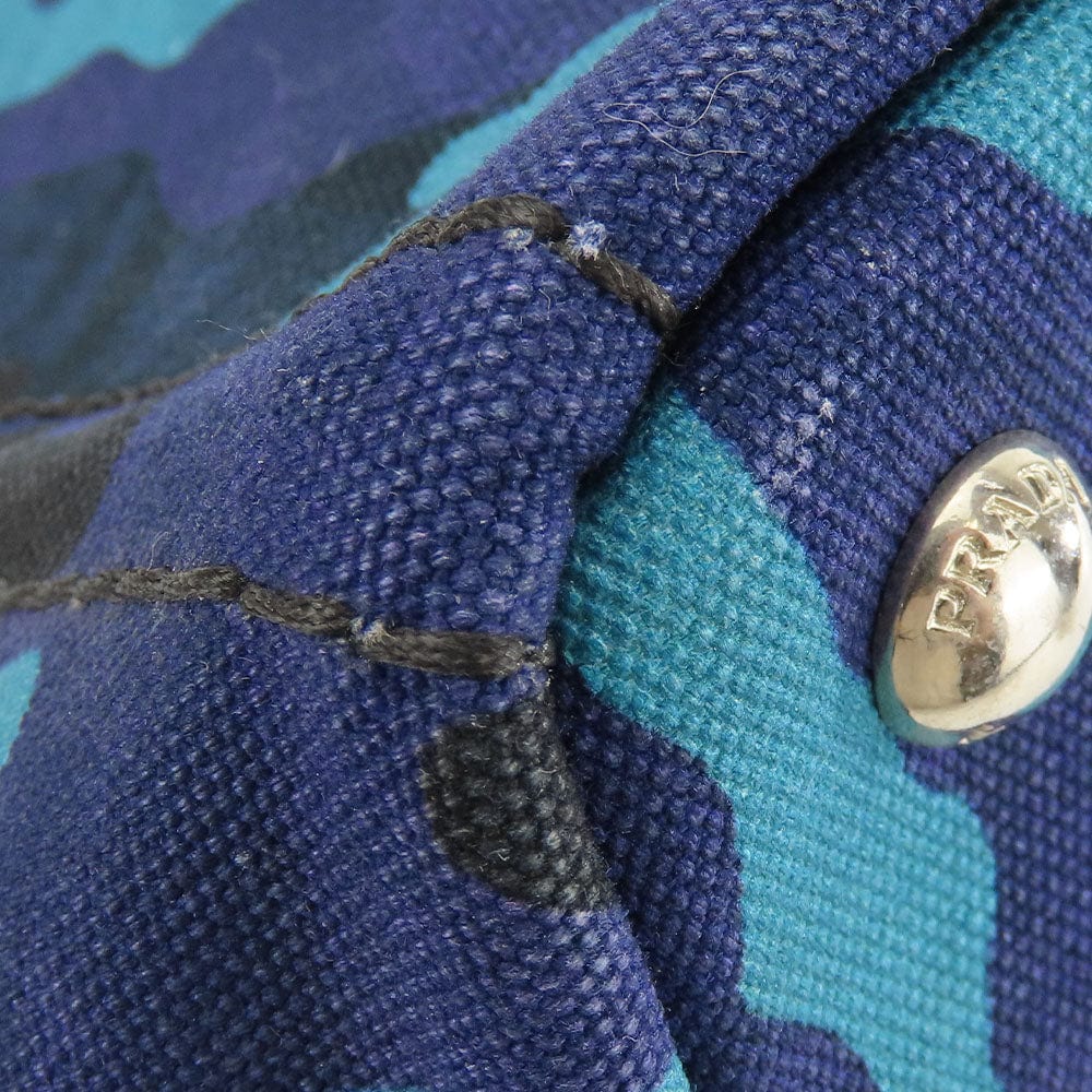 Close-up of a blue and teal fabric with a button, featuring the brand 'Pepita'.