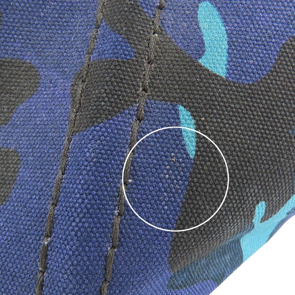 Close-up of a blue and black camouflage-patterned fabric with a circle highlighting a small defect.