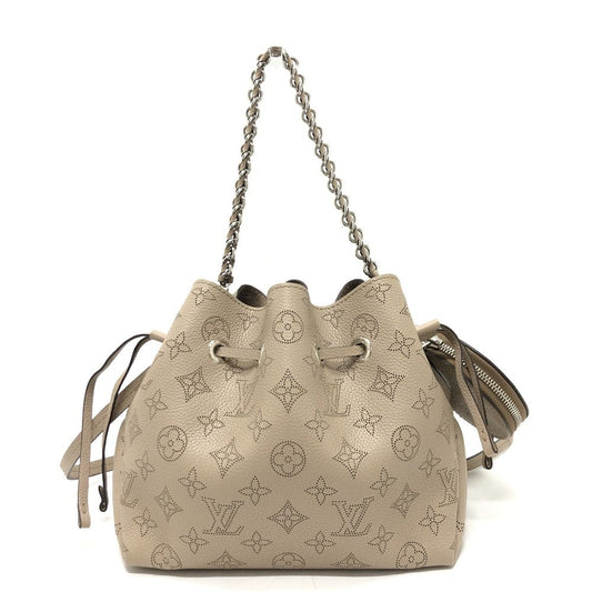 Beige handbag with monogram pattern on a white background