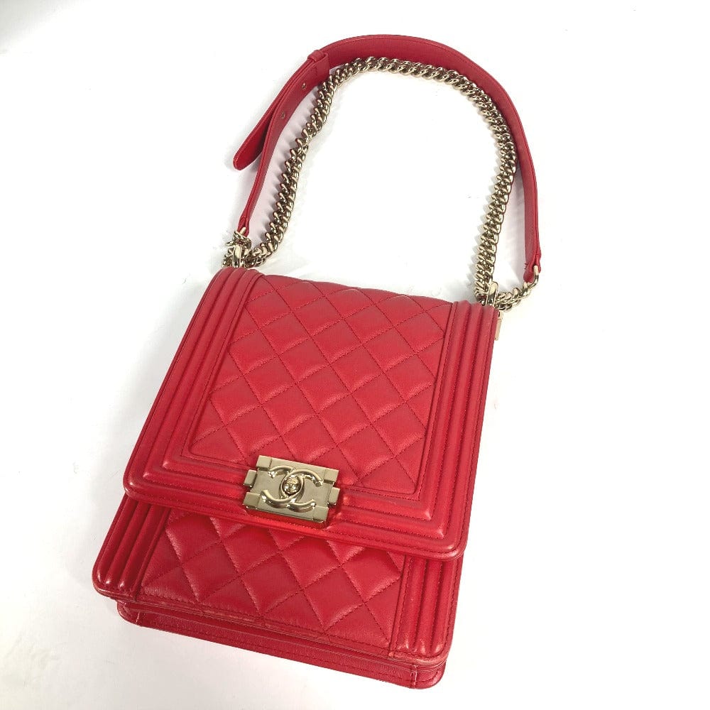 Red quilted handbag with gold chain strap on a white background