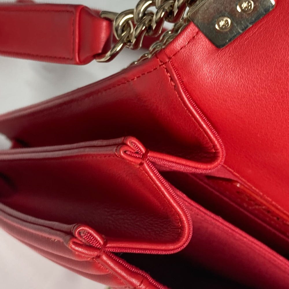Close-up of a red handbag with gold chain detail