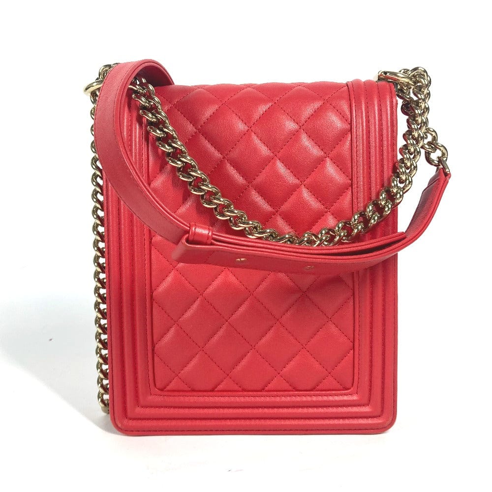 Red quilted handbag with gold chain strap on a white background