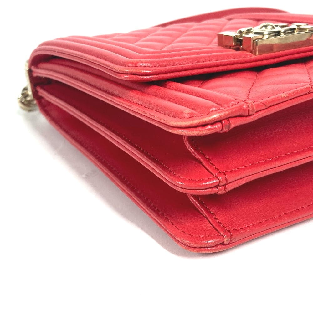 Close-up of a red quilted handbag with a gold clasp on a white background