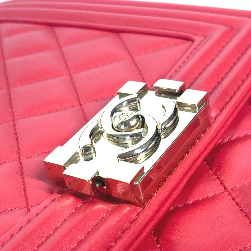 Close-up of a pink quilted handbag with a gold and silver logo.