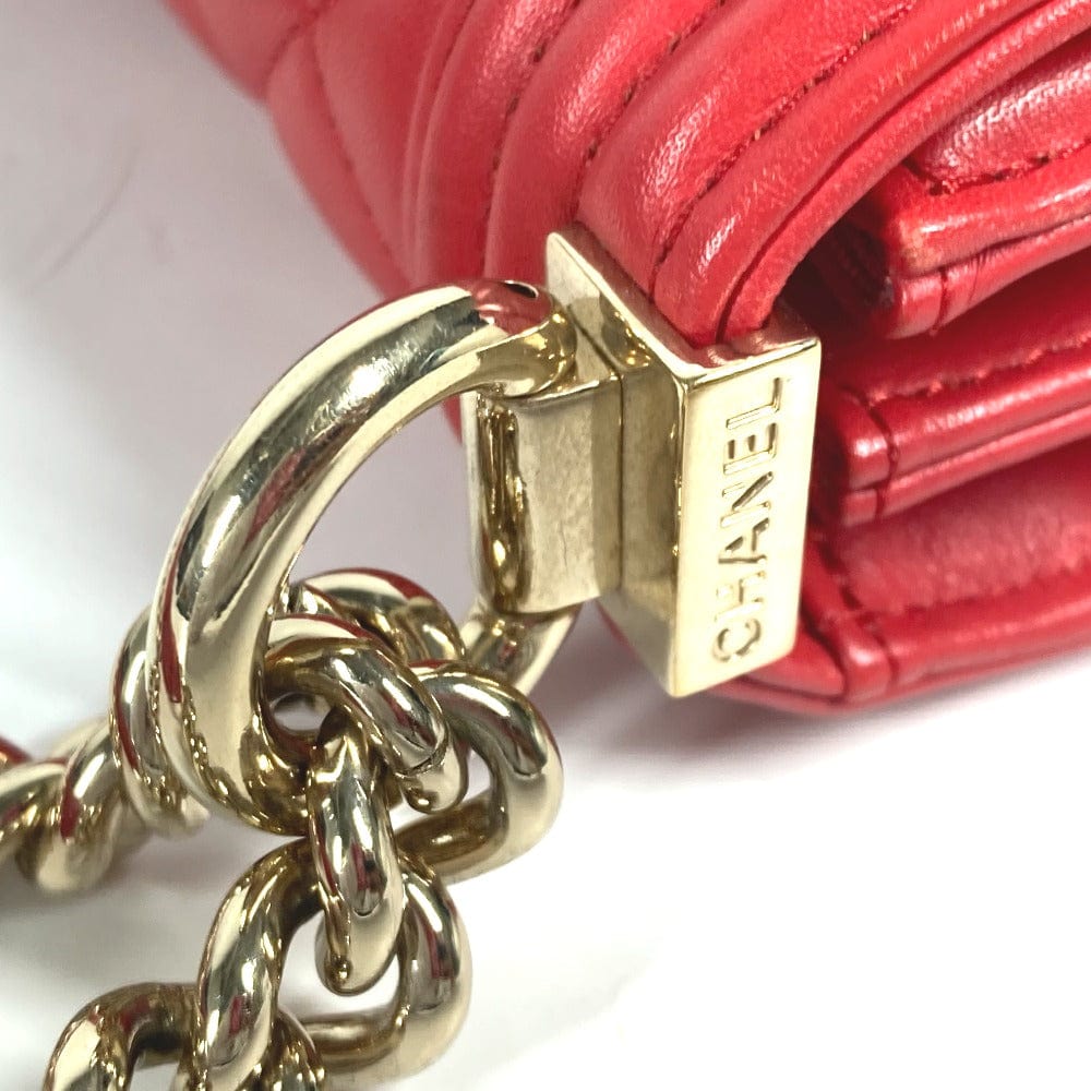 Close-up of a red Chanel handbag with gold chain strap on a white background