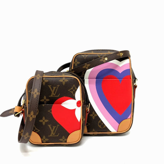 Two Louis Vuitton bags with heart designs on a white background