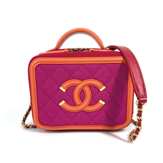 Pink and orange handbag with gold chain detail on a white background