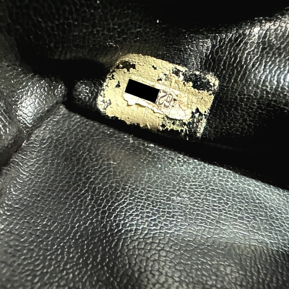 Close-up of a gold lock on black leather surface