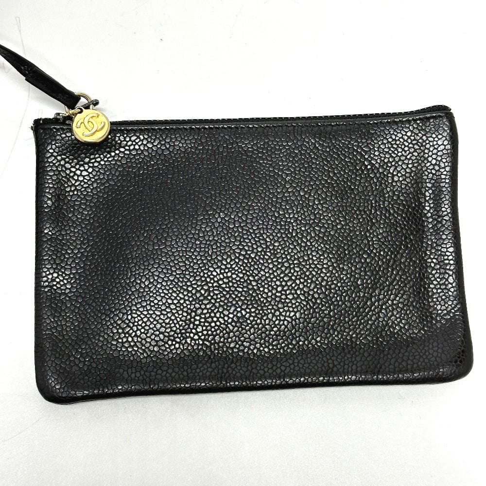 Black textured clutch bag with a gold zipper on a white background