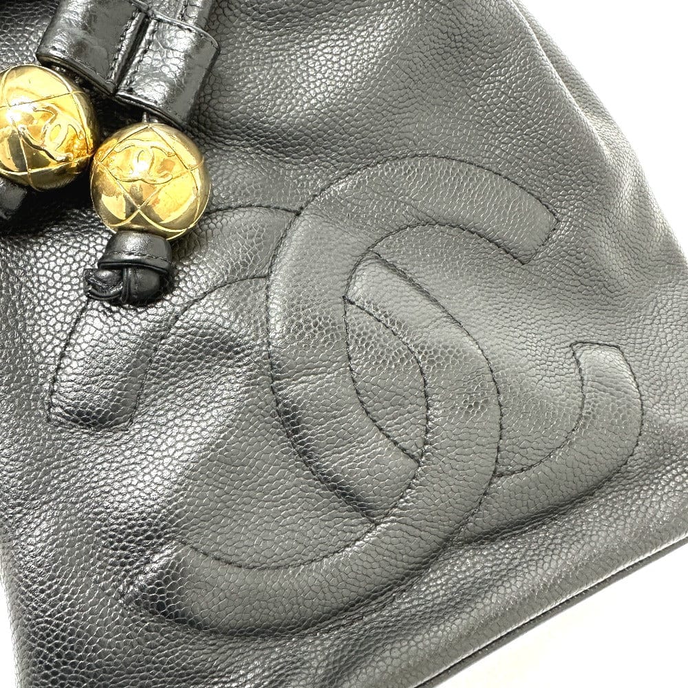 Close-up of a black leather handbag with gold hardware and Chanel logo.