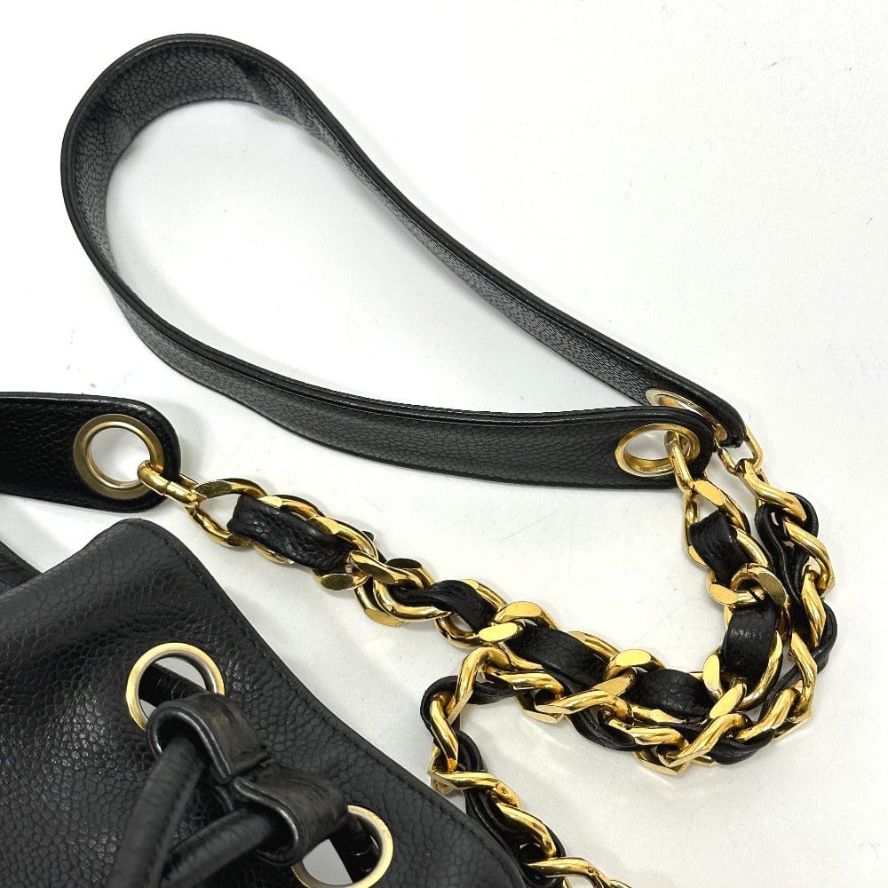 Black leather handbag with gold chain strap on a white background