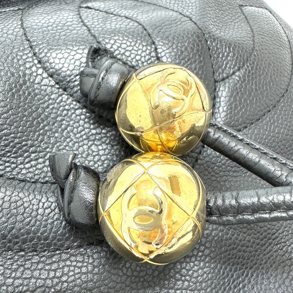 Gold Chanel beads on a textured gray surface