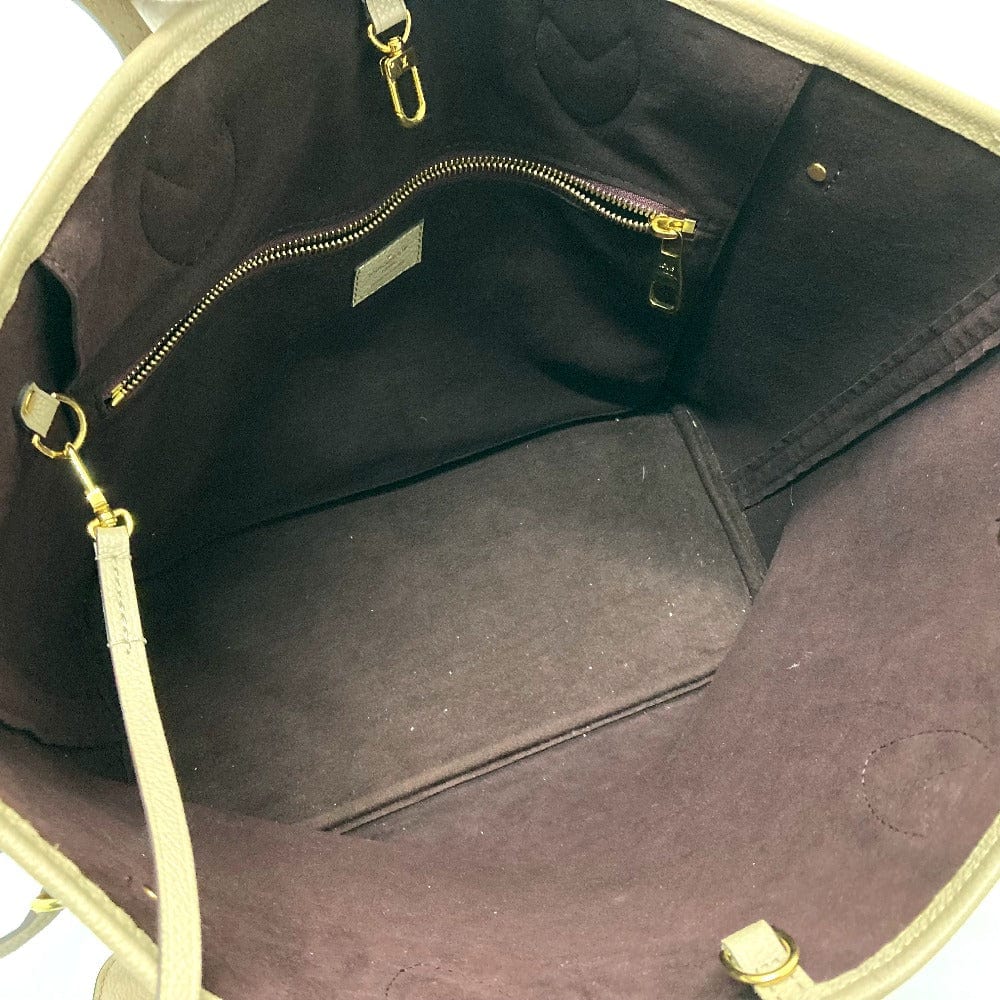 Close-up of a brown leather bag with gold zipper and handle.