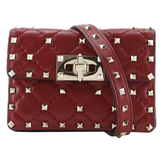 Red quilted handbag with silver studs and a gold clasp on a white background