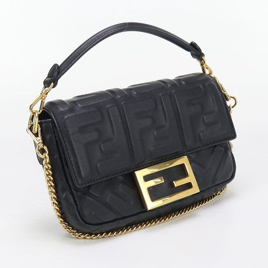 Black handbag with gold accents on a white background