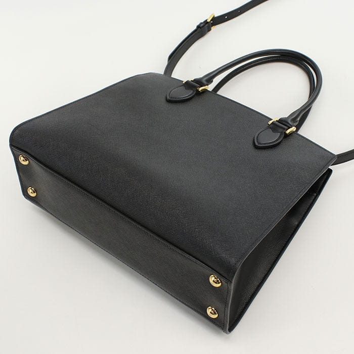 Black handbag with gold accents on a white background