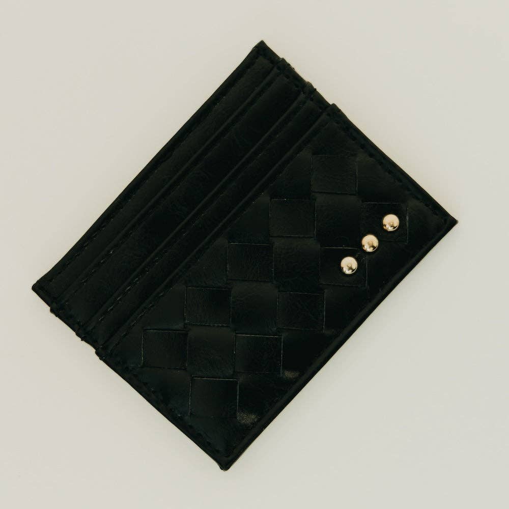 Black woven clutch with gold buttons on a light gray background