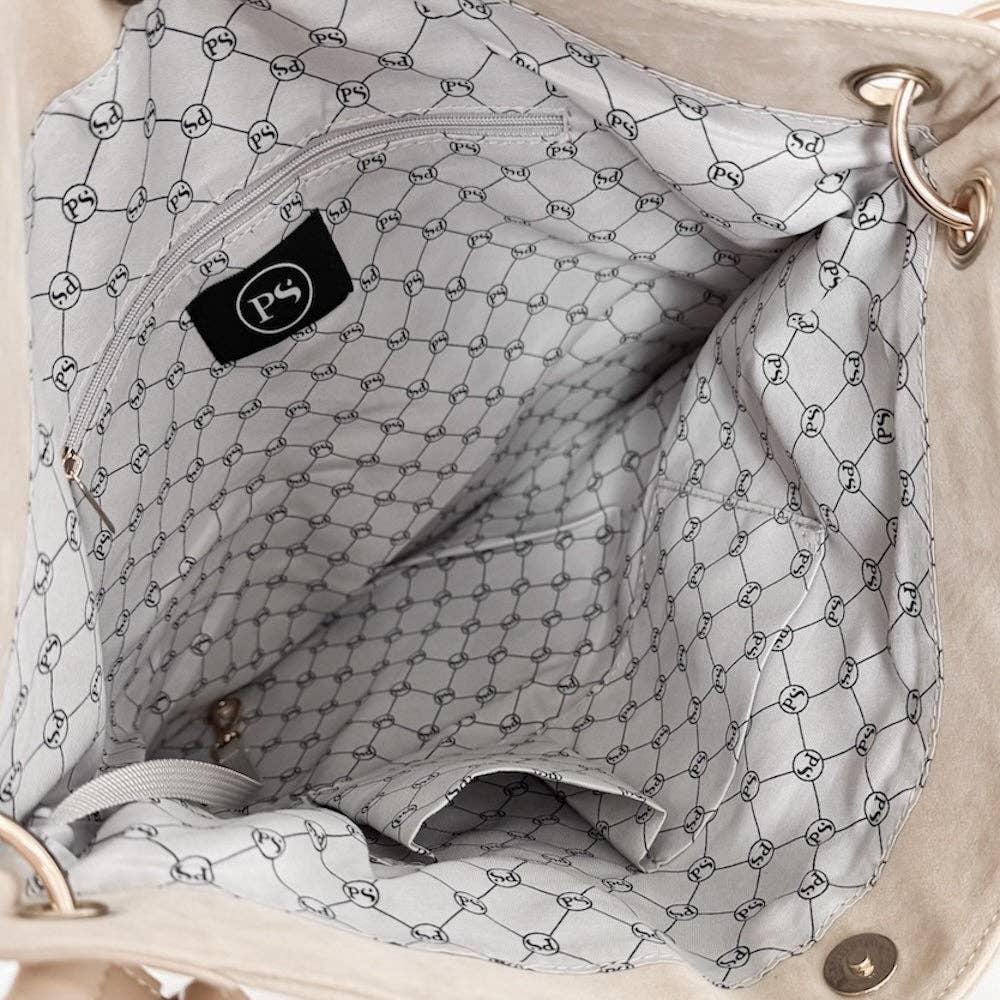 Close-up of a beige handbag with a patterned interior and visible brand logo.