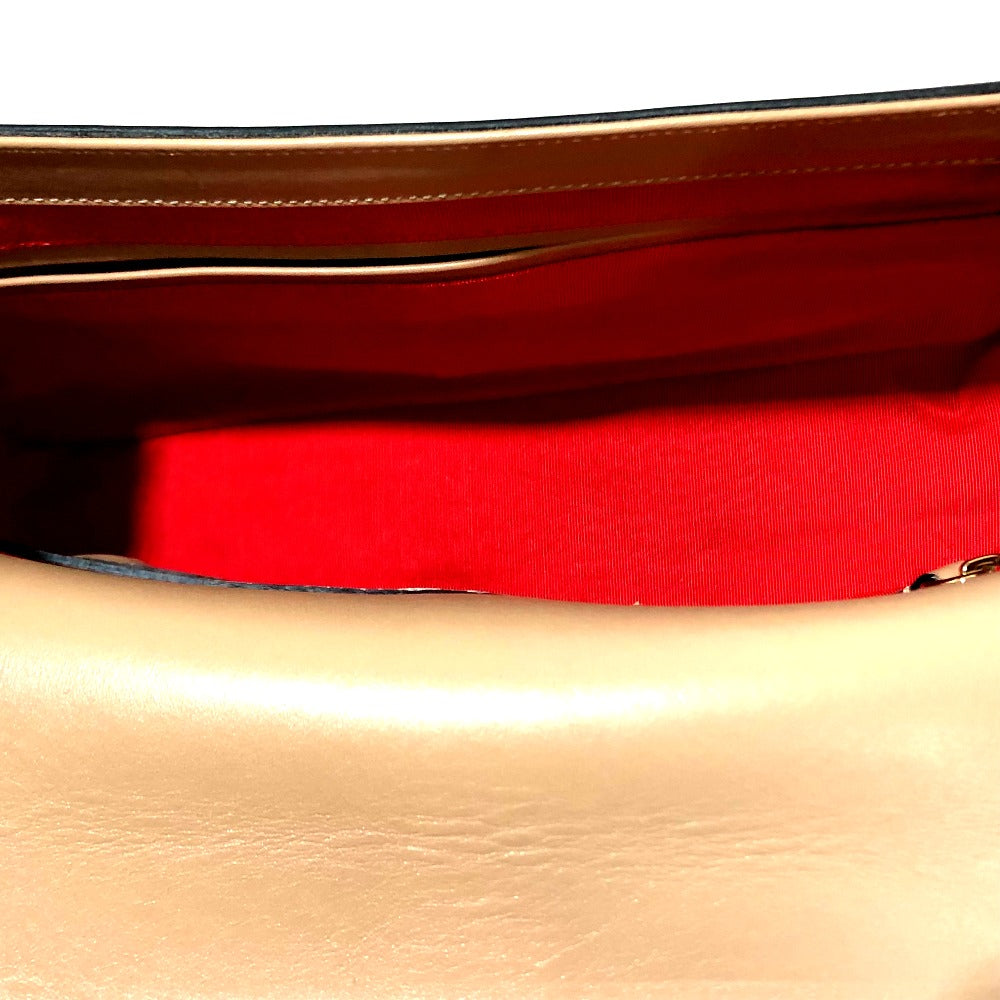 Close-up of a red belt with gold buckle on a beige surface